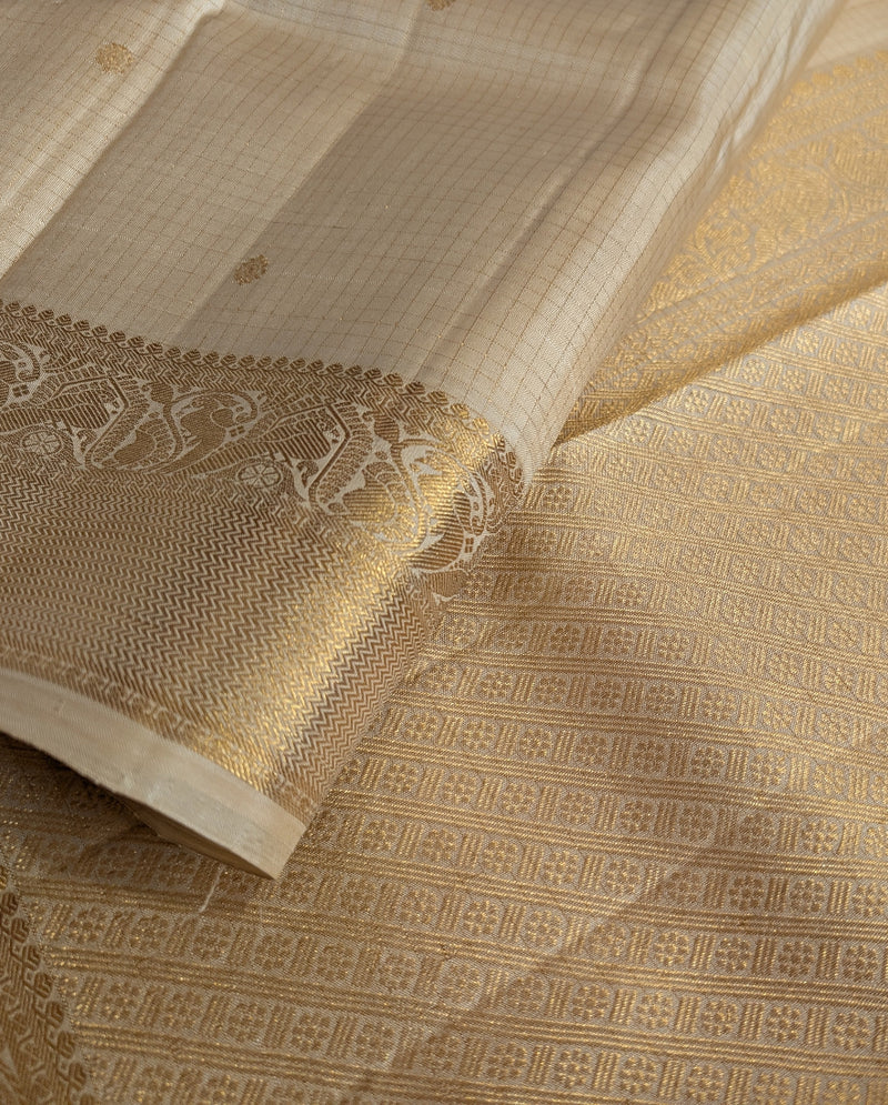 A close-up pic of a cream kanjivaram silk saree